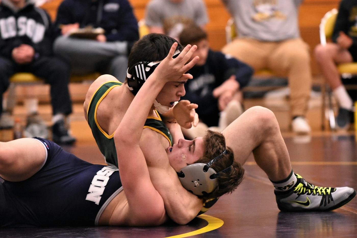 Two wrestlers on the mat during a match